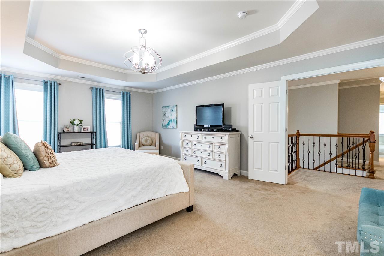 8240 Clarks Branch Drive Raleigh, NC 27613 - Photo 18 of 30 a spacious bedroom with a bed and a flat tv screen on dresser
