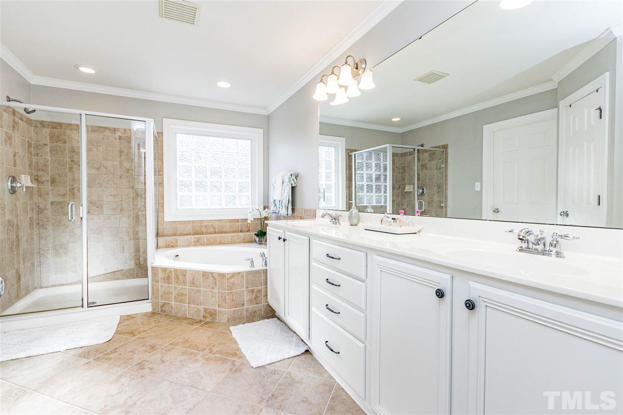 8240 Clarks Branch Drive Raleigh, NC 27613 - Photo 19 of 30 a bathroom with a granite countertop sink mirror and a bathtub