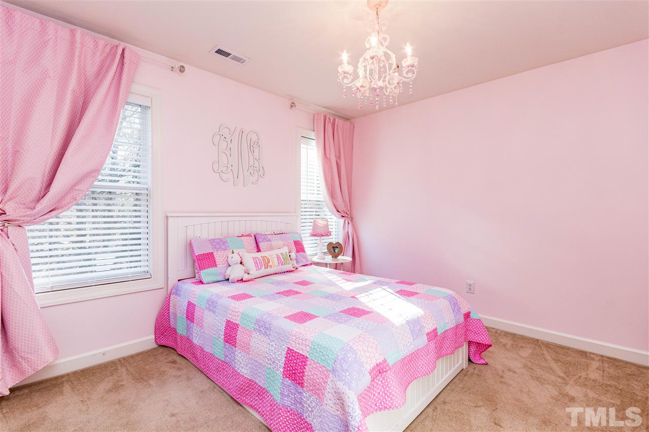 8240 Clarks Branch Drive Raleigh, NC 27613 - Photo 20 of 30 a bedroom with a bed chandelier and a window