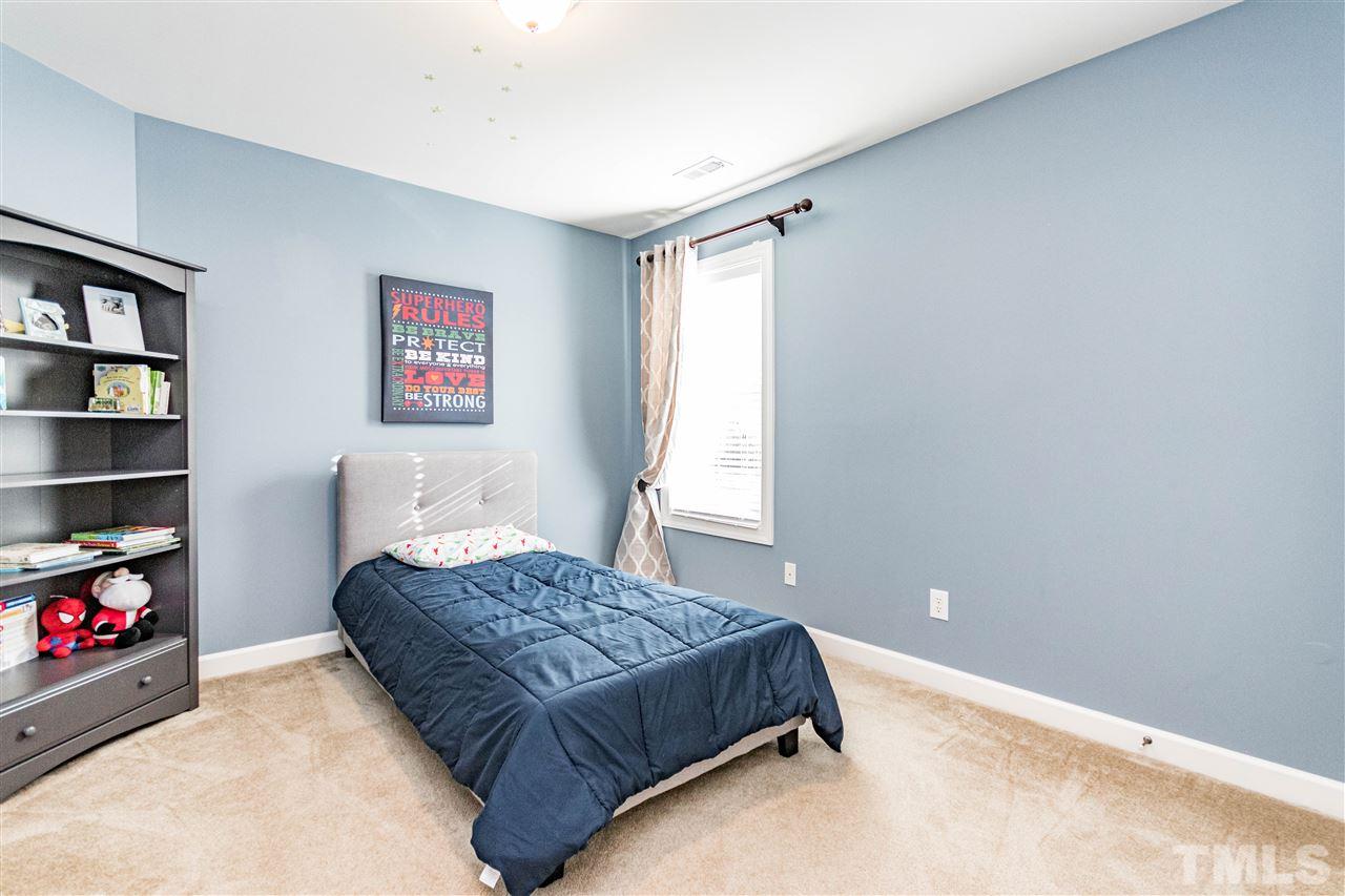 8240 Clarks Branch Drive Raleigh, NC 27613 - Photo 22 of 30 a bedroom with a bed a cabinet and a book shelf
