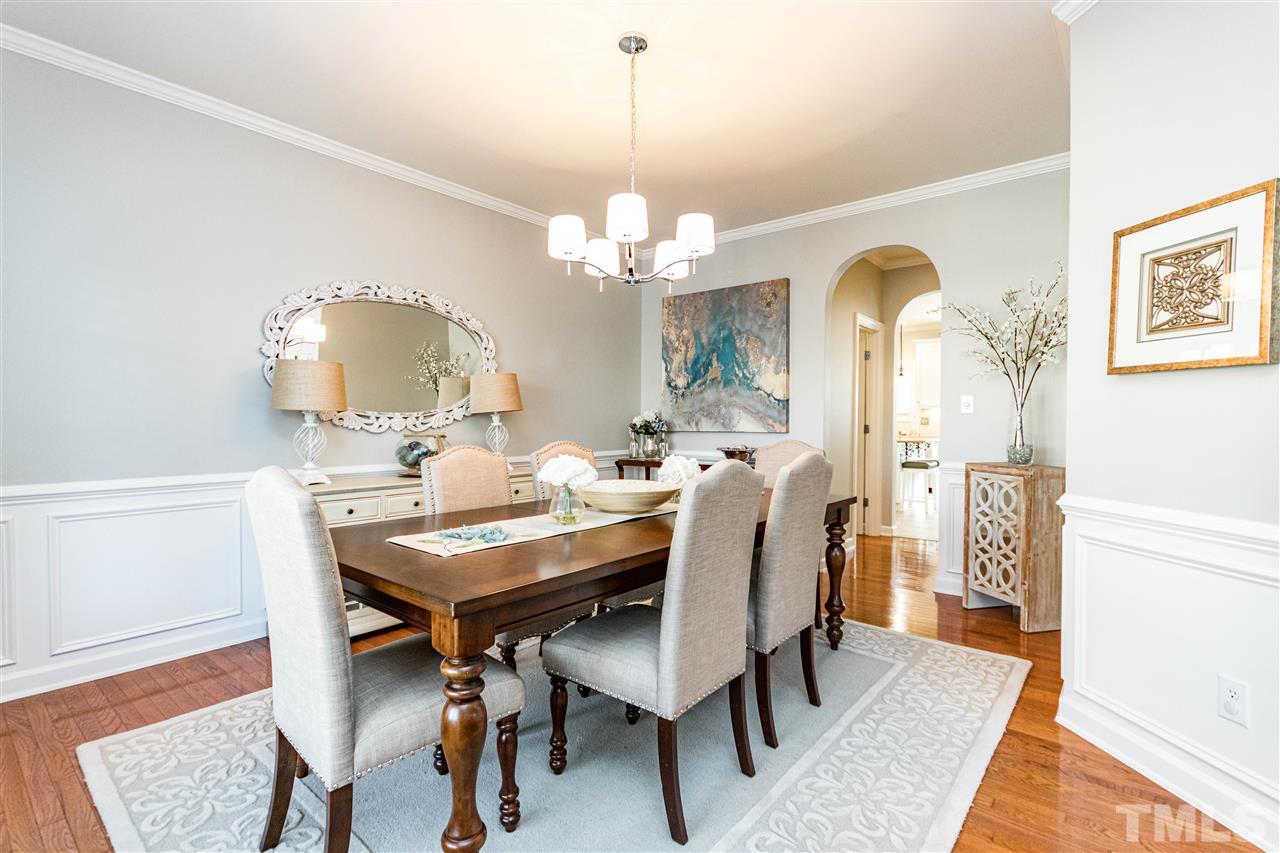 8240 Clarks Branch Drive Raleigh, NC 27613 - Photo 4 of 30 a dining room with wooden floor a chandelier a wooden table and chairs