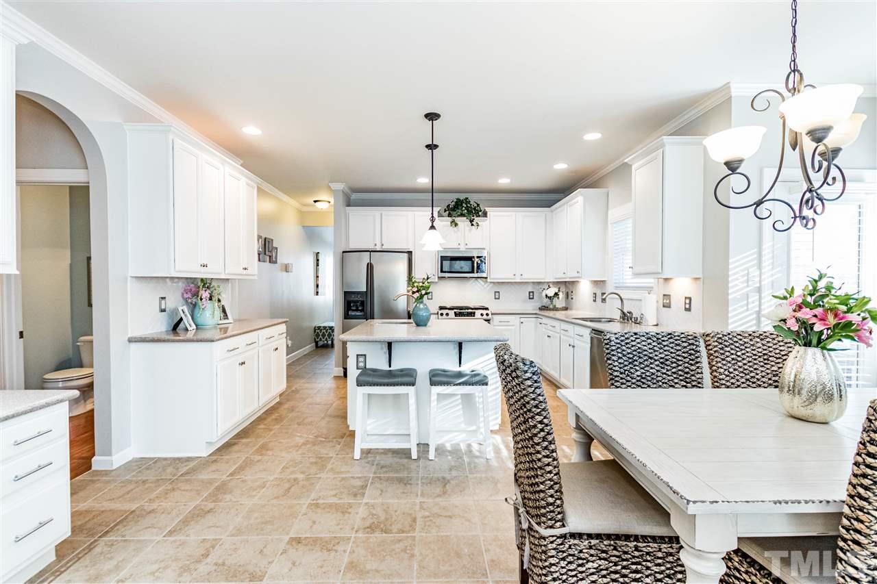 8240 Clarks Branch Drive Raleigh, NC 27613 - Photo 10 of 30 a large kitchen with kitchen island a white counter space a sink appliances and cabinets