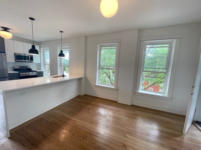 2159 West Huron Street, Unit 2R Chicago, IL 60612 - Photo 3 of 13 a view of a kitchen with wooden floor and windows