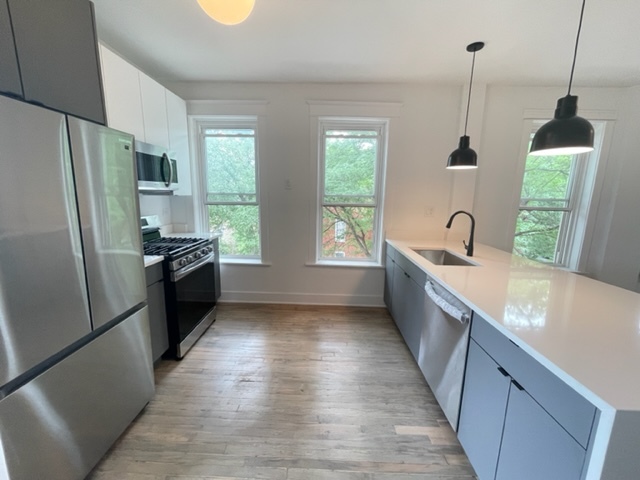 2159 West Huron Street, Unit 2R Chicago, IL 60612 - Photo 5 of 13 a view of a kitchen with a sink oven and refrigerator