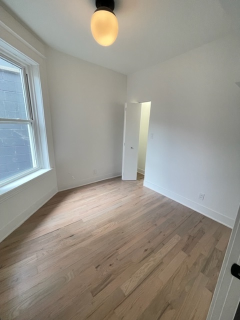 2159 West Huron Street, Unit 2R Chicago, IL 60612 - Photo 10 of 13 an empty room with wooden floor and windows