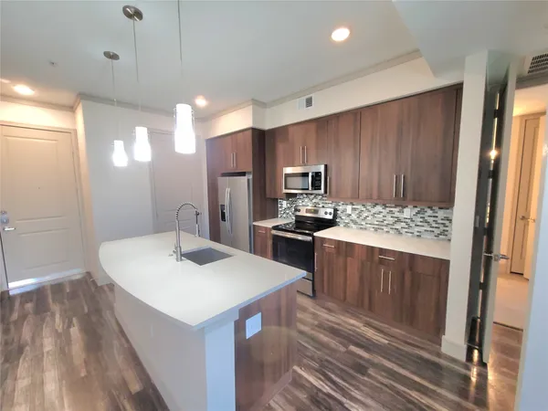 a kitchen with a sink refrigerator and microwave