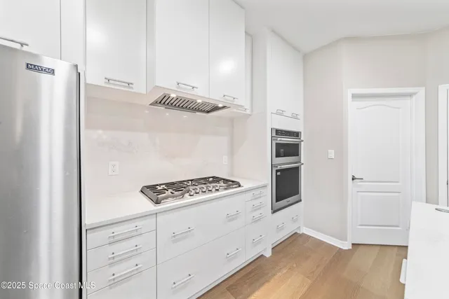 a spacious bedroom with a bed and a chandelier