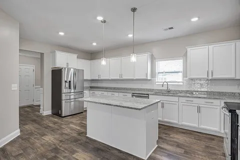 a kitchen with a refrigerator a sink and dishwasher a oven with wooden floor