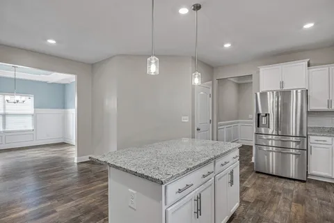 a kitchen with kitchen island a sink stainless steel appliances and refrigerator