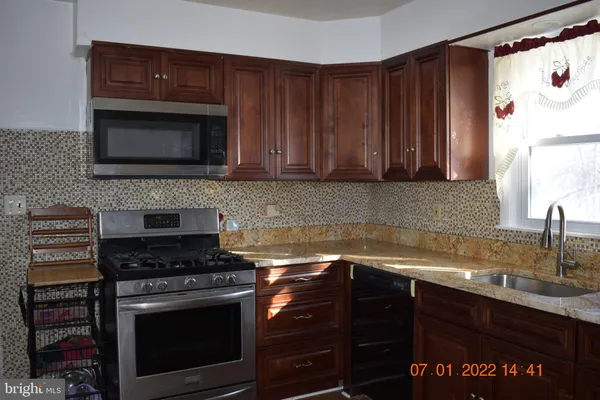 a kitchen with granite countertop a stove and a sink