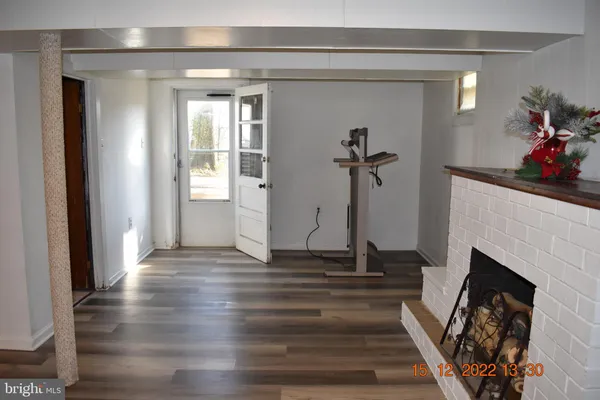 a view of a livingroom with wooden floor and a fireplace