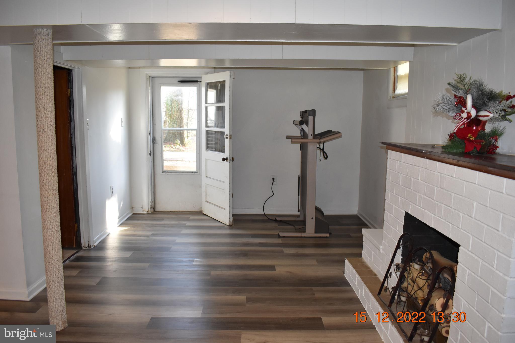 9113 Kinzer Street Lanham, MD 20706 - Photo 6 of 6 a view of a livingroom with wooden floor and a fireplace