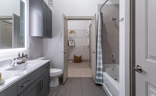 a bathroom with a granite countertop sink toilet and shower