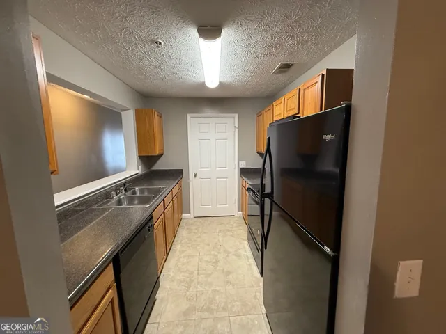 a kitchen with stainless steel appliances granite countertop a refrigerator and a stove