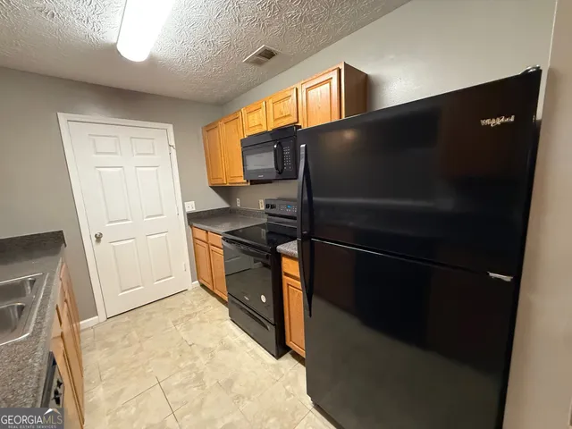 a kitchen with a refrigerator and a stove