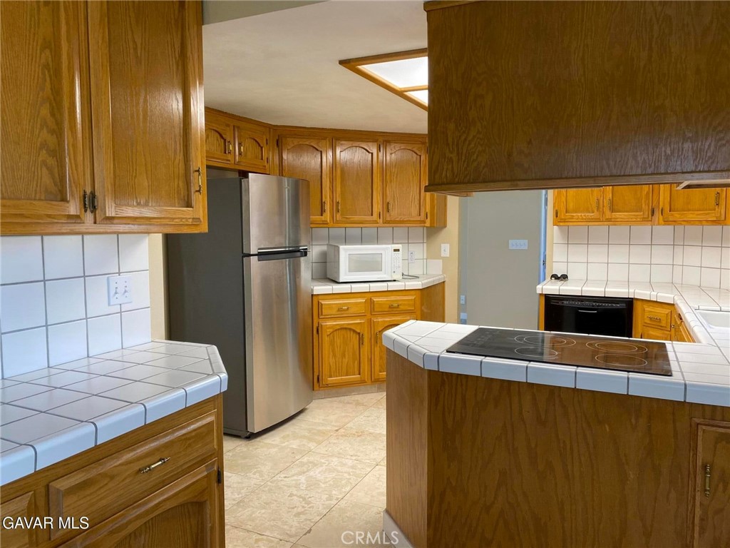 22601 Player Court Tehachapi, CA 93561 - Photo 5 of 10 a kitchen with stainless steel appliances granite countertop a sink a stove and a refrigerator