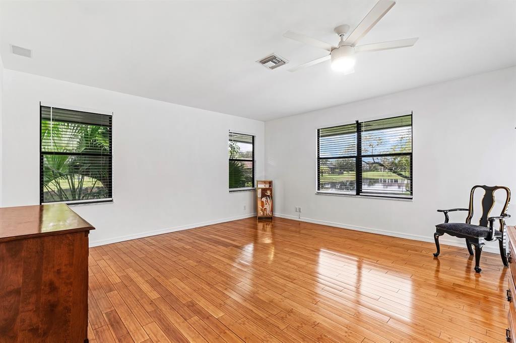 10158 Southeast Acorn Way Jupiter, FL 33469 - Photo 22 of 39 a view of an empty room with window a ceiling fan and wooden floor