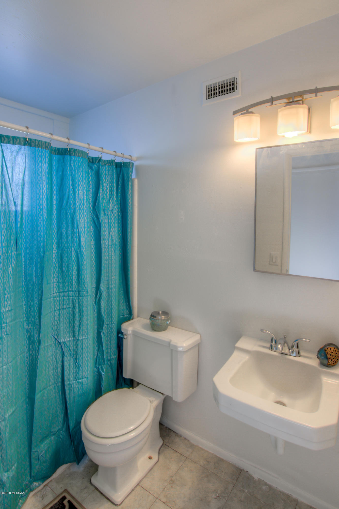 1841 West Astolat Road Tucson, AZ 85713 - Photo 10 of 40 a white toilet sitting next to a bathroom sink