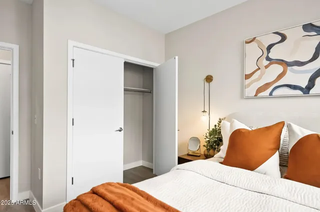 a bedroom with a bed and a painting on the wall