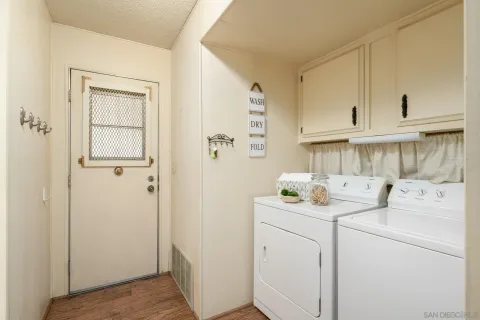 a view of washer and dryer with white cabinets