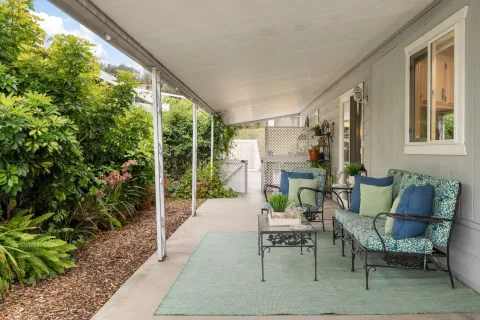 a view of a patio with table and chairs potted plants and floor to ceiling window