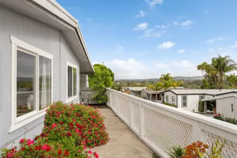 a balcony with flower plants and wooden fence