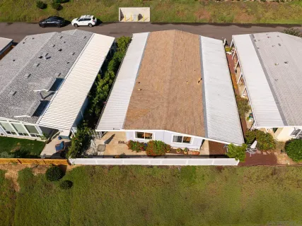 a view of swimming pool with seating space and trees in the background