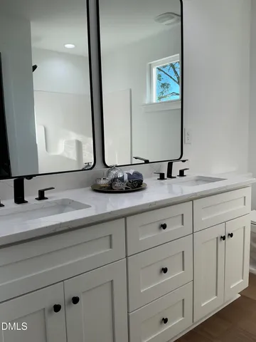 a bathroom with double sink and a mirror