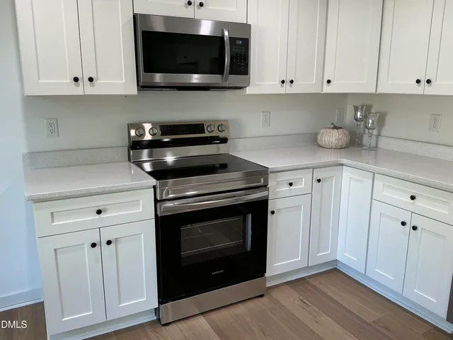 a kitchen with white cabinets and stainless steel appliances
