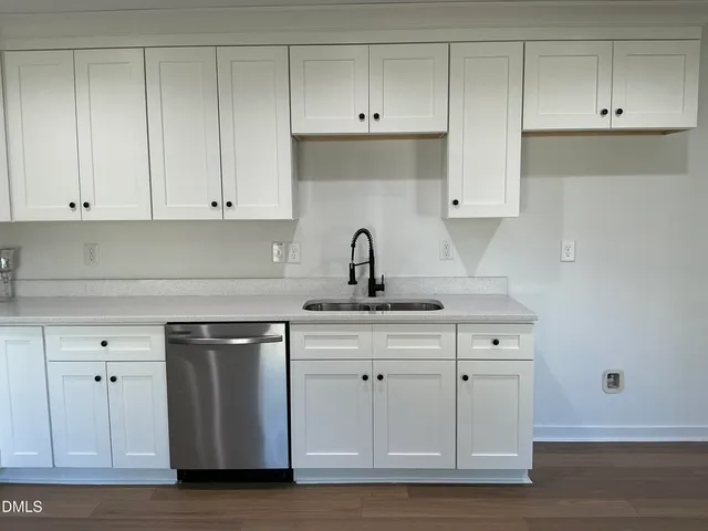a kitchen with white cabinets and a sink