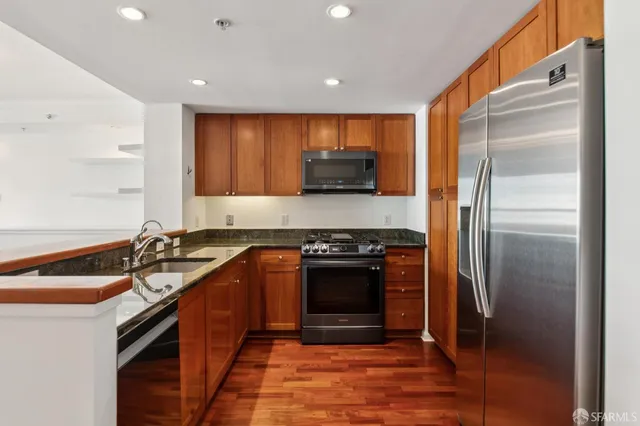 a kitchen with stainless steel appliances granite countertop a refrigerator and a sink