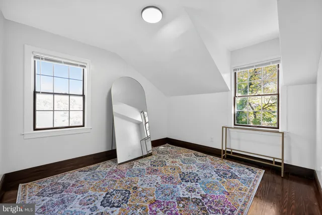 an empty room with window and wooden floor