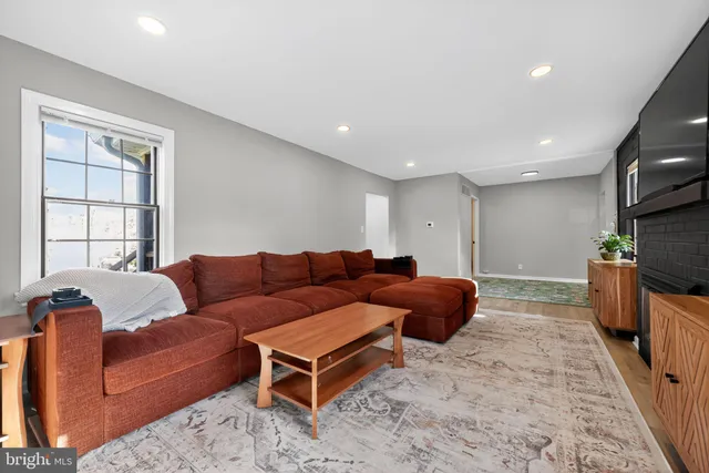 a living room with furniture a flat screen tv and a fireplace