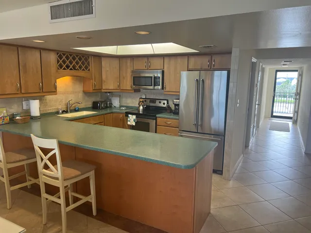 a kitchen with stainless steel appliances granite countertop a sink refrigerator and cabinets