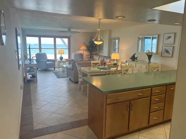 a kitchen with a sink cabinets and living room view