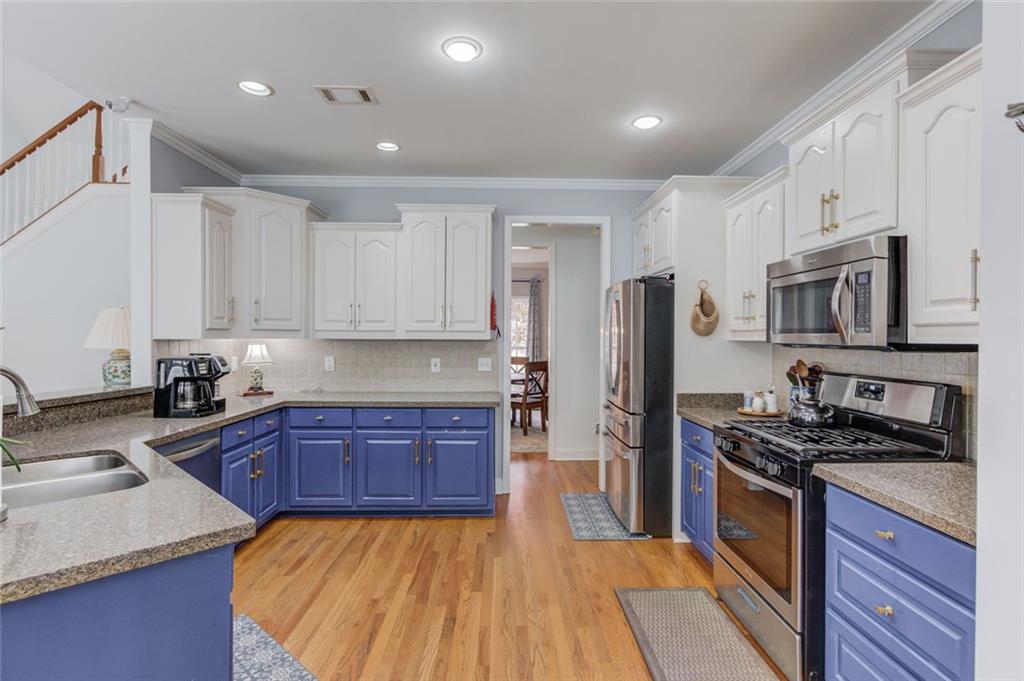 124 Dumar Lane Hoschton, GA 30548 - Photo 12 of 49 a kitchen with stainless steel appliances granite countertop a sink stove microwave and refrigerator