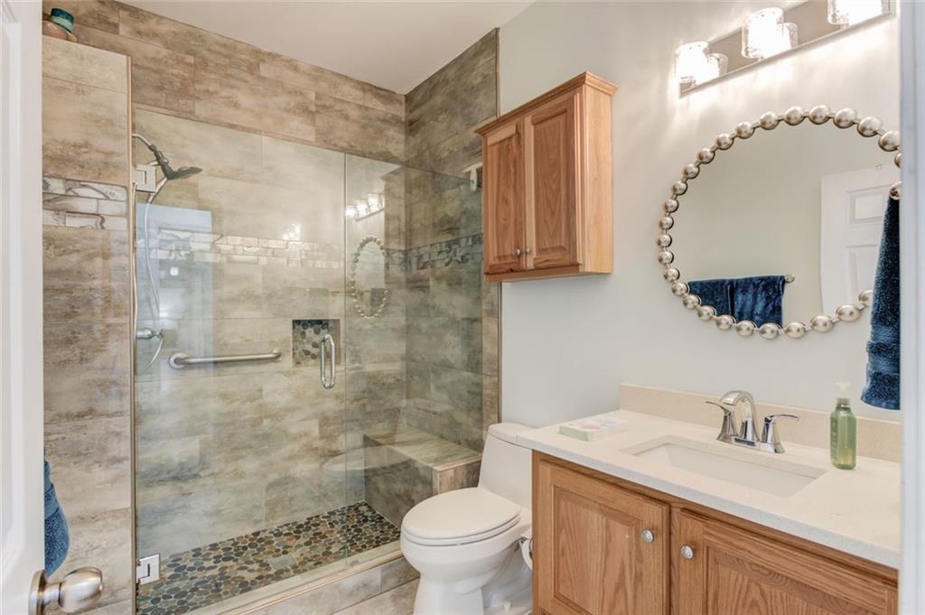 124 Dumar Lane Hoschton, GA 30548 - Photo 22 of 49 a bathroom with a granite countertop sink mirror toilet and shower
