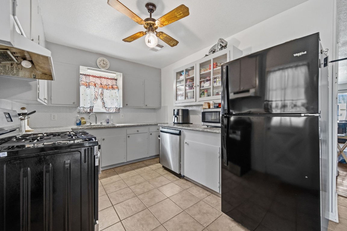 400 Dora Street Cleveland, TX 77328 - Photo 14 of 19 a kitchen with a stove a sink and a refrigerator
