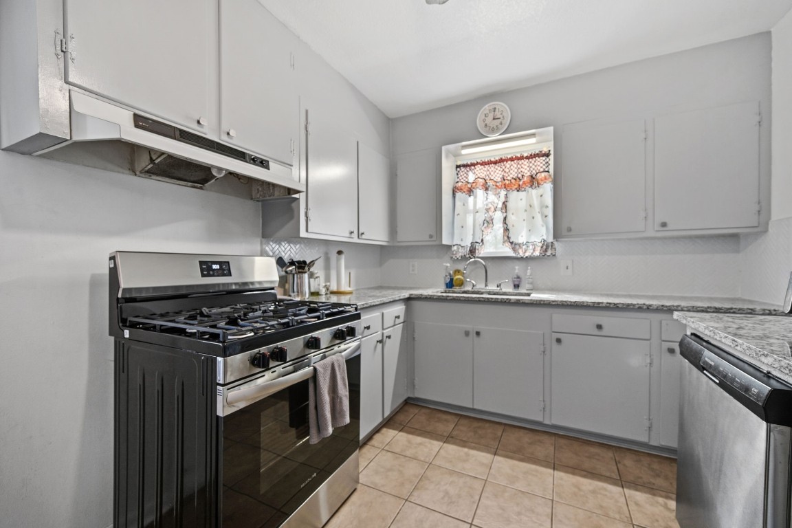 400 Dora Street Cleveland, TX 77328 - Photo 15 of 19 a kitchen with stainless steel appliances granite countertop a stove a sink and a microwave