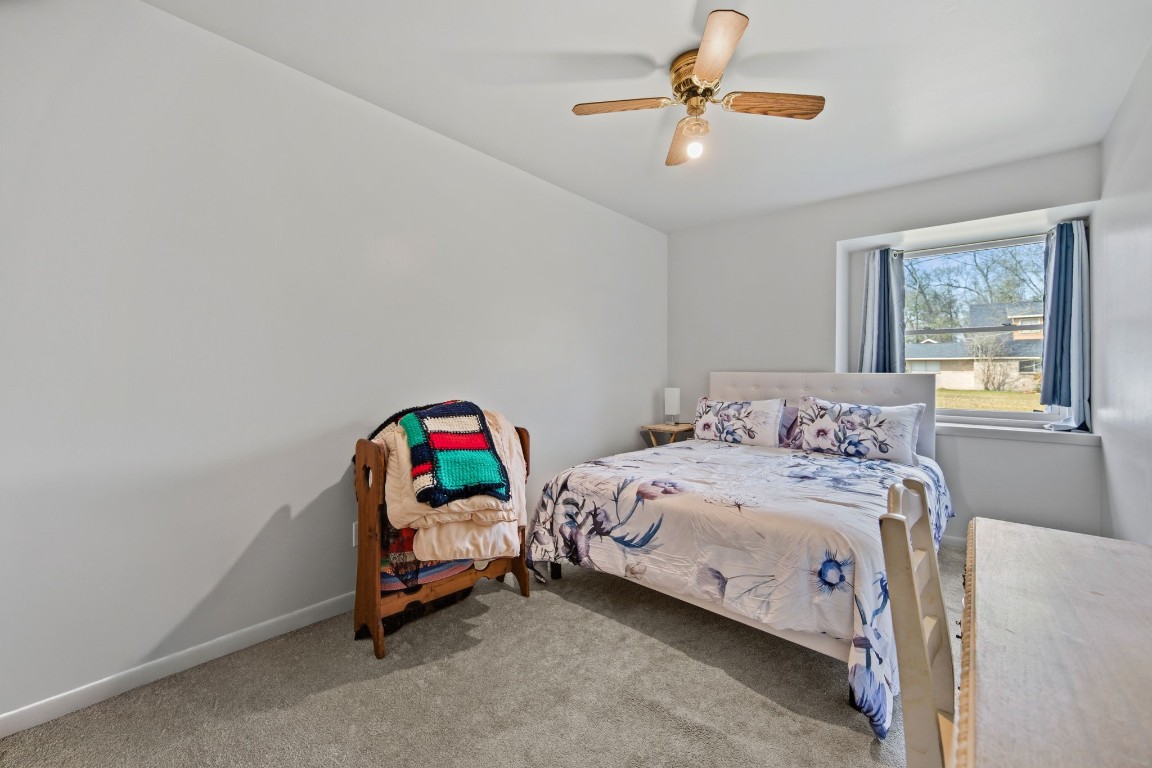 400 Dora Street Cleveland, TX 77328 - Photo 17 of 19 a bedroom with a bed a chandelier and a chandelier