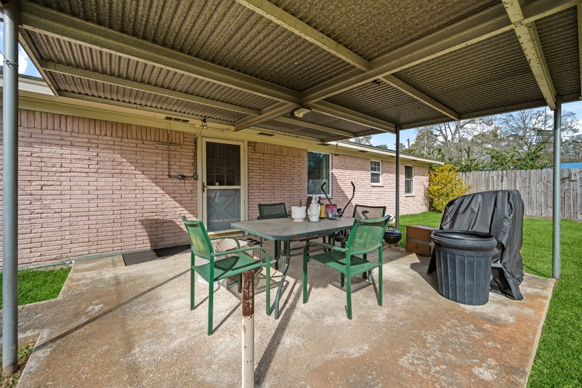 400 Dora Street Cleveland, TX 77328 - Photo 7 of 19 a view of patio with table and chairs under an umbrella with a barbeque