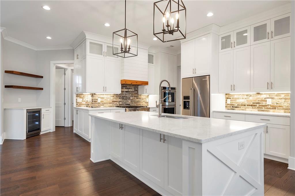 254 Fortress Way Jefferson, GA 30549 - Photo 22 of 69 a kitchen with stainless steel appliances granite countertop a refrigerator a sink dishwasher a stove and white cabinets with wooden floor