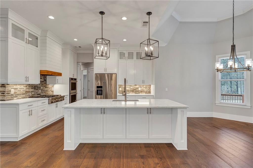 254 Fortress Way Jefferson, GA 30549 - Photo 23 of 69 a large kitchen with granite countertop a stove a sink a refrigerator and a fireplace