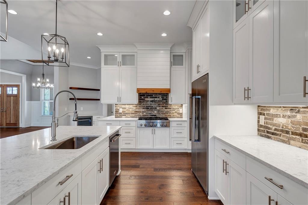 254 Fortress Way Jefferson, GA 30549 - Photo 25 of 69 a kitchen with stainless steel appliances kitchen island a refrigerator sink and cabinets