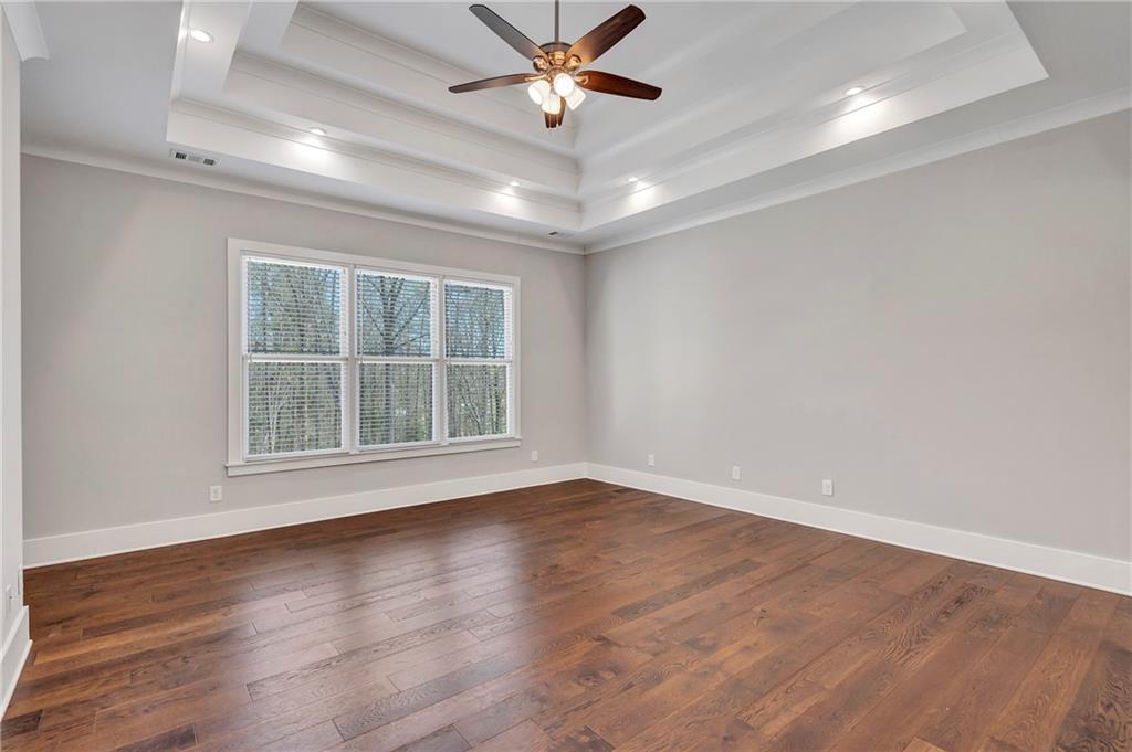 254 Fortress Way Jefferson, GA 30549 - Photo 28 of 69 an empty room with wooden floor chandelier fan and windows