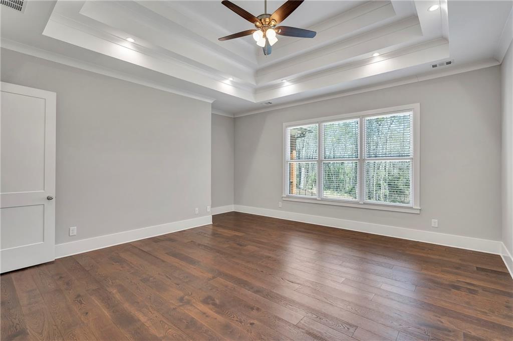 254 Fortress Way Jefferson, GA 30549 - Photo 30 of 69 an empty room with wooden floor chandelier fan and windows