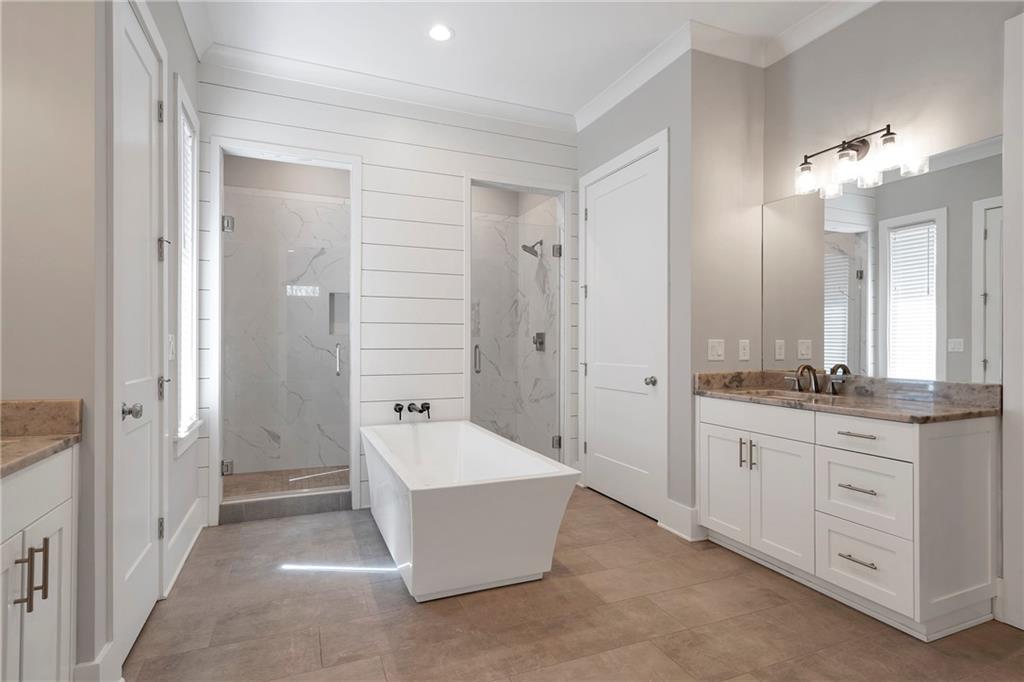 254 Fortress Way Jefferson, GA 30549 - Photo 31 of 69 a spacious bathroom with a granite countertop sink a mirror and a bathtub