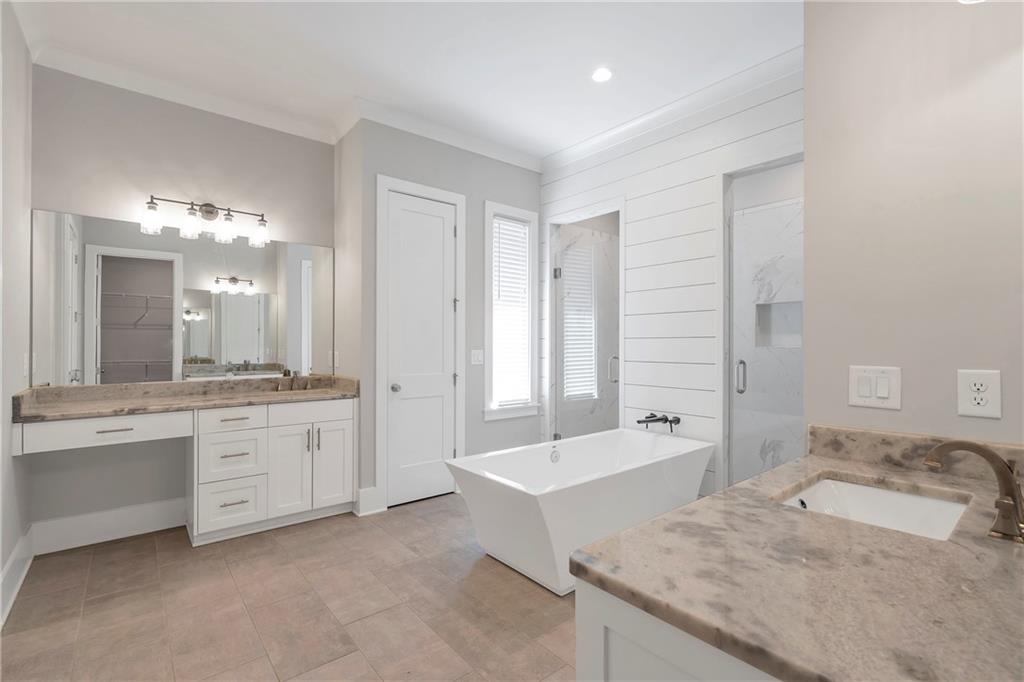 254 Fortress Way Jefferson, GA 30549 - Photo 34 of 69 a spacious bathroom with a granite countertop double vanity sink a mirror and a bathtub