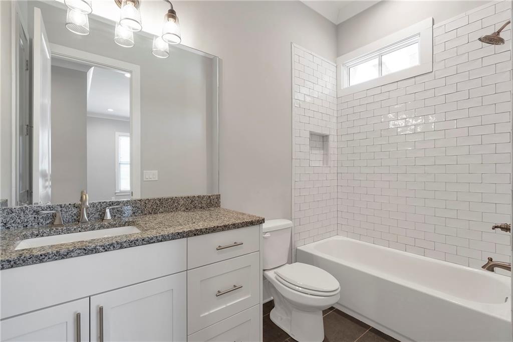 254 Fortress Way Jefferson, GA 30549 - Photo 46 of 69 a bathroom with a granite countertop sink a toilet a mirror a bathtub and shower