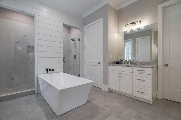 a kitchen with stainless steel appliances granite countertop white cabinets and a wooden floor
